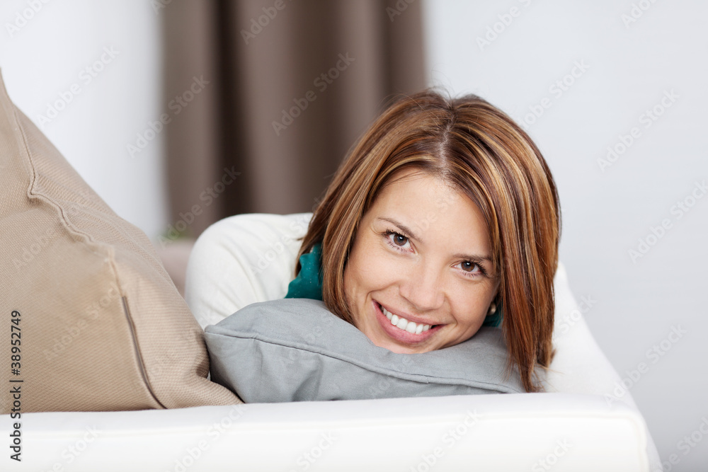 lachende frau mit kissen auf dem sofa lachende frau mit kissen auf dem sofa