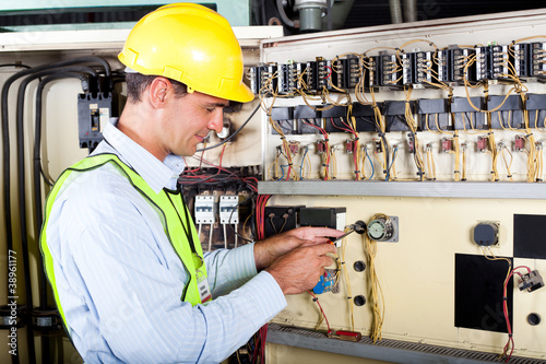 electrician changing industrial machine switch photo