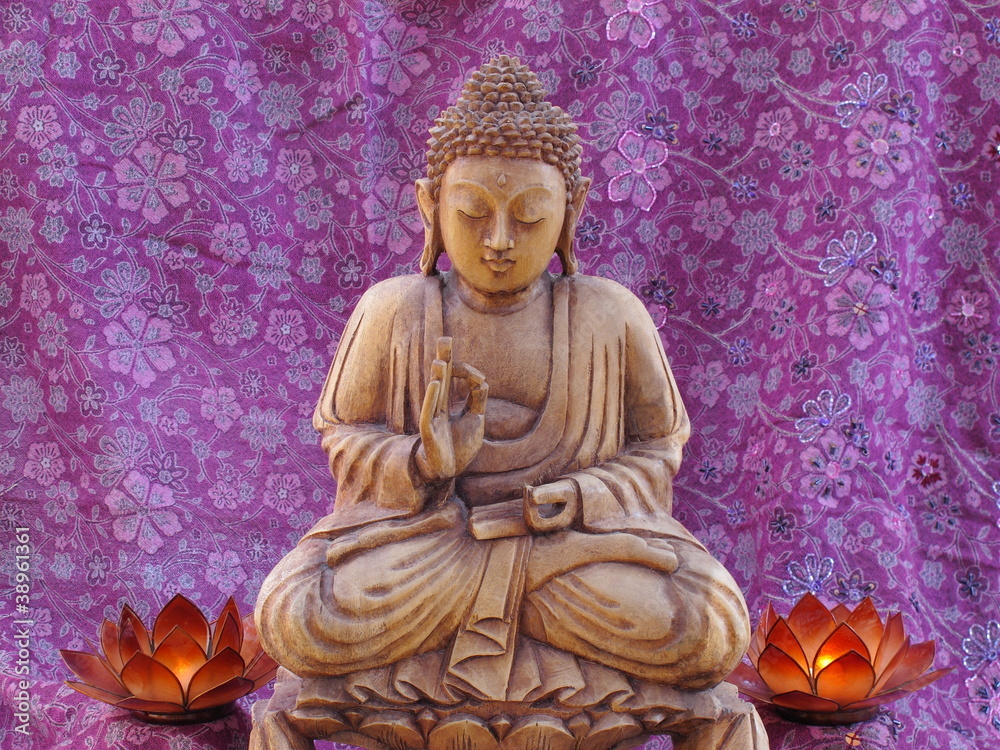 Fototapeta premium Buddha geschnitzt mit zwei Lotoskerzen