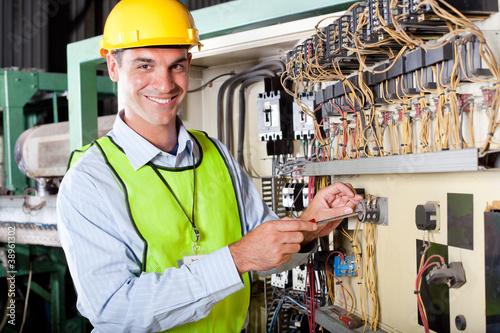 technician repairing industrial machine control box