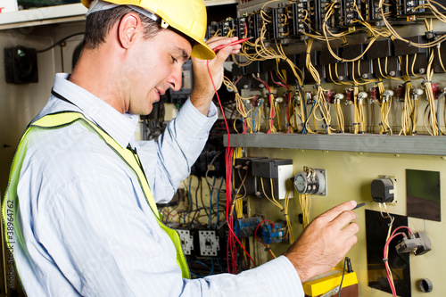 male caucasian electrician testing industrial machine photo