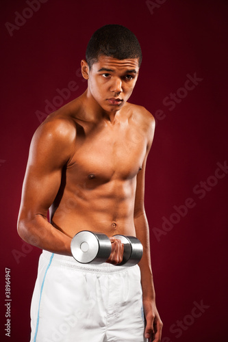 young fit man lifting dumbell