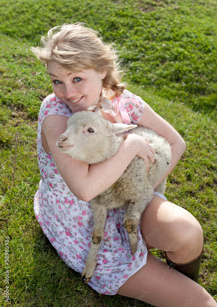 Young pretty cheerful blond woman with lamb on a countryside Young pretty cheerful blond woman with lamb on a countryside