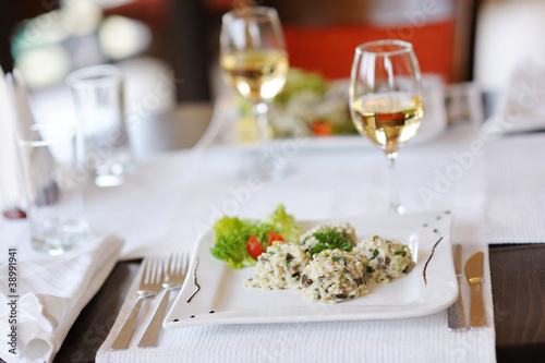 Delicious risotto with tomato and lettuce on a white plate © MNStudio
