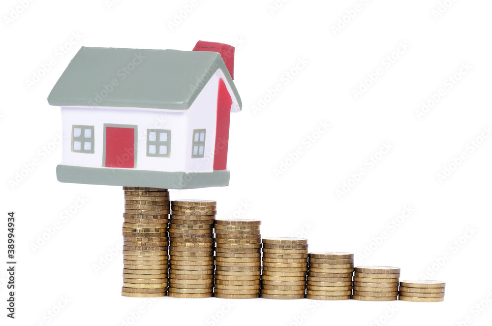 Toy small house and coins in the form of the diagram. concept Toy small house and coins in the form of the diagram. concept
