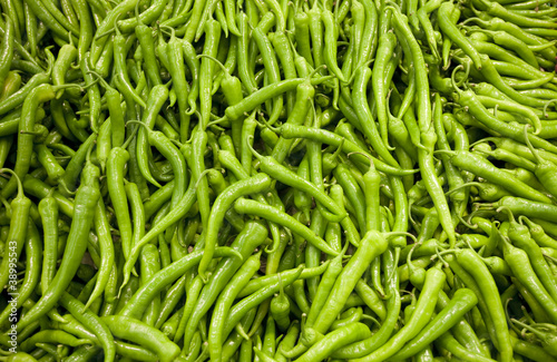 Pile of green peppers forming a background