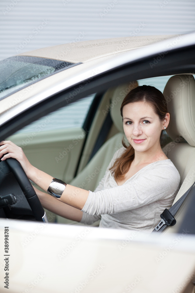 Pretty young woman driving her new car