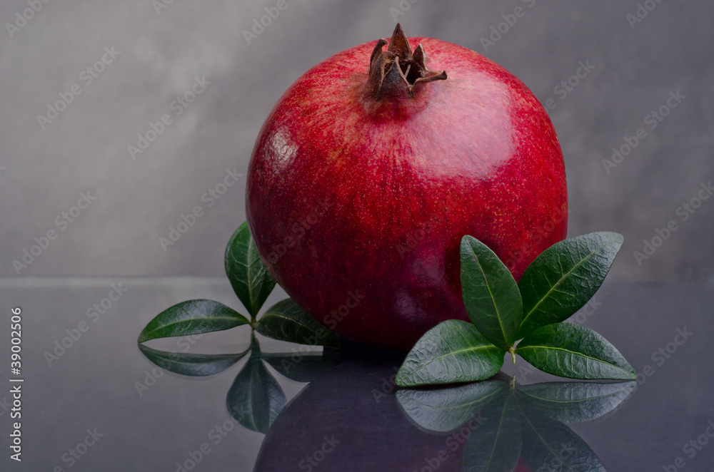 Pomegranate With Green Leaves On A Dark Background Pomegranate With Green Leaves On A Dark Background