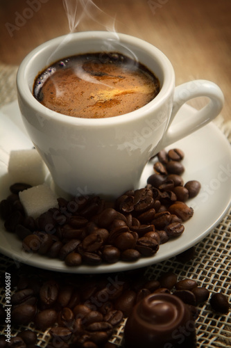 A small cup of strong coffee on the brown background