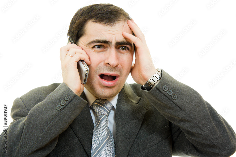 Businessman in distress speaks by phone on a white background Businessman in distress speaks by phone on a white background