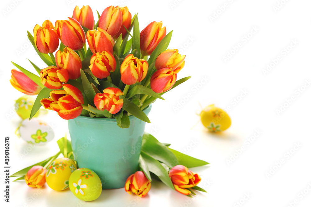 Beautiful bouquet of tulips in vase with Easter eggs on white ba