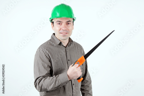 Man in protective helmet with a handsaw