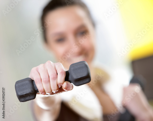 dumbbell in hand of working out young smiling female