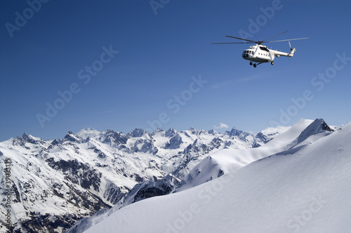 Helicopter in snowy mountains photo