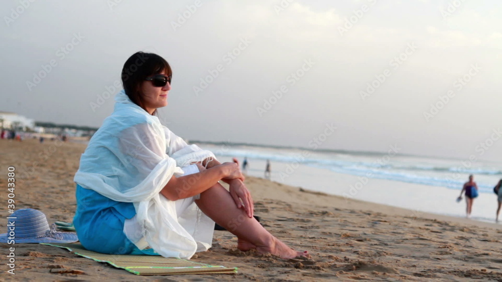 Woman relaxing on the beach by the sea Woman relaxing on the beach by the sea