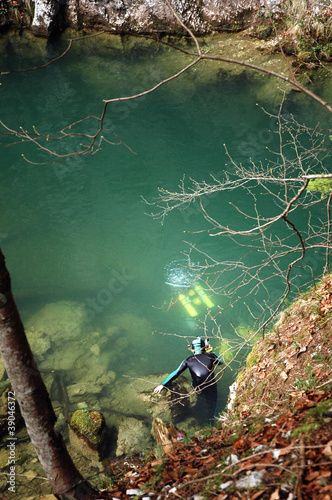 A cave diver emerges from a spring