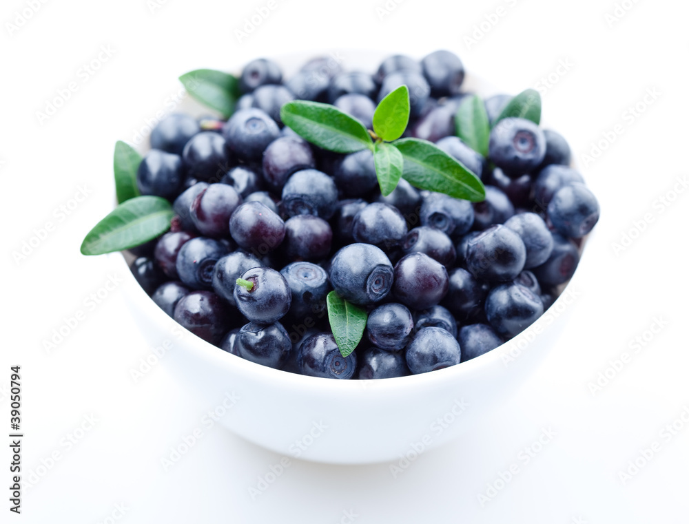 Blueberries with leaves in plate. isolated on white background Blueberries with leaves in plate. isolated on white background