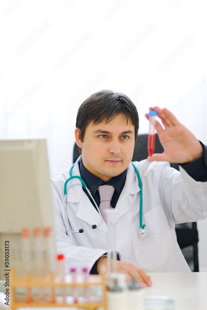 Medical doctor checking tube with blood sample Medical doctor checking tube with blood sample