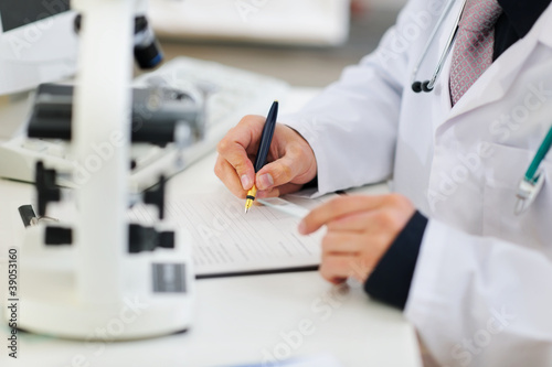 Closeup on hands of medical doctor working with documents