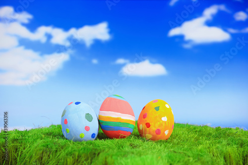 Easter eggs on grass with blue sky and cloud background