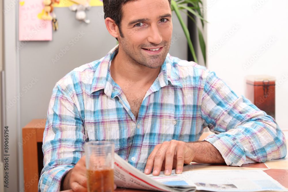 Man reading the newspaper while having a refreshment Man reading the newspaper while having a refreshment