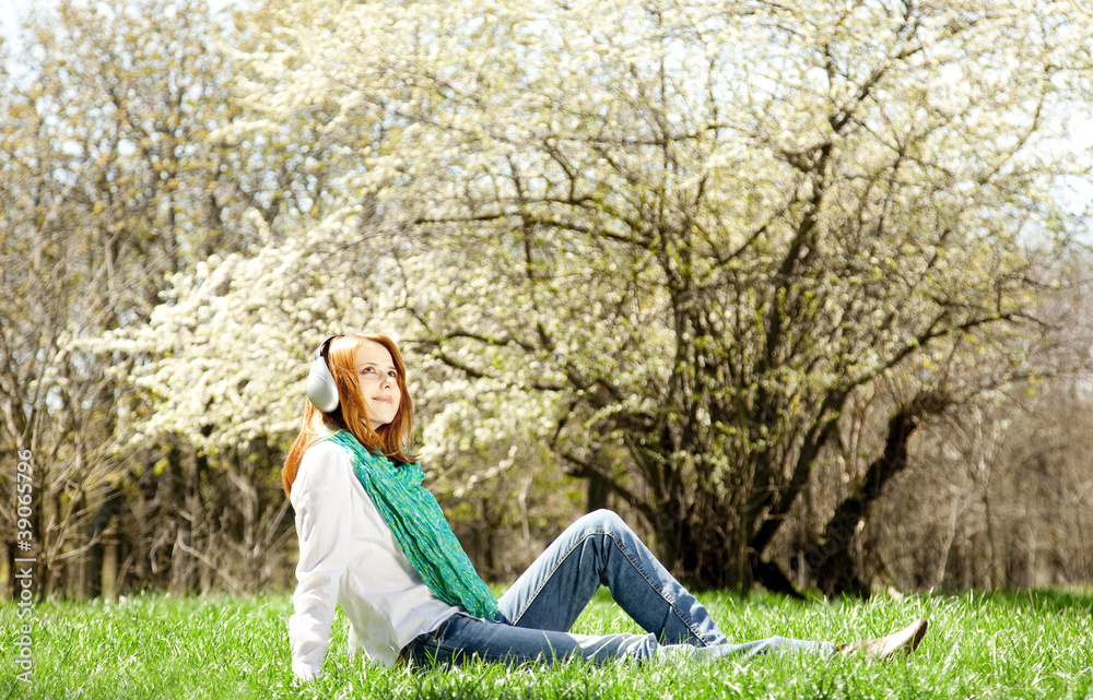 Redhead girl with headphone in the park. Redhead girl with headphone in the park.