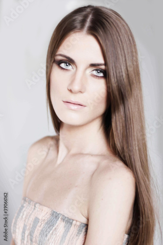 Portrait of a beautiful young girl with long hair in studio