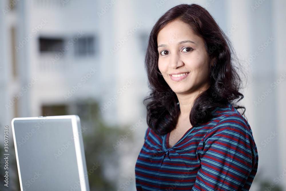 Indian female student working with laptop outdoors Indian female student working with laptop outdoors