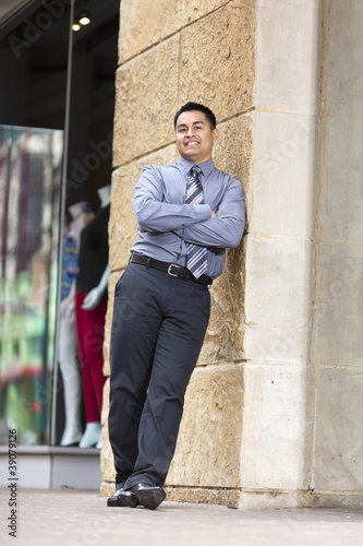 Hispanic Businessman - Leaning on stone wall
