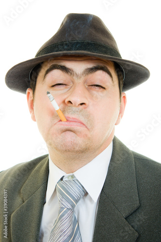 A businessman in a hat smokes on a white background.