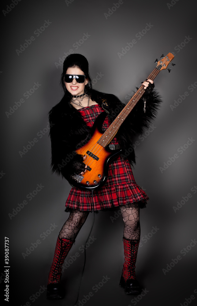 Fashion style photo of young rocked woman in studio with guitar Fashion style photo of young rocked woman in studio with guitar