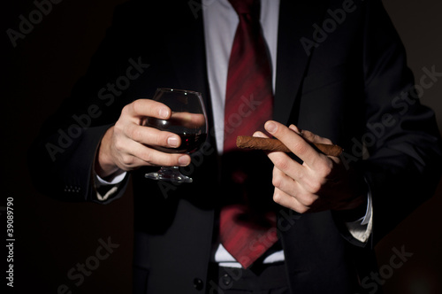 rich person, holds a cigar and whisky