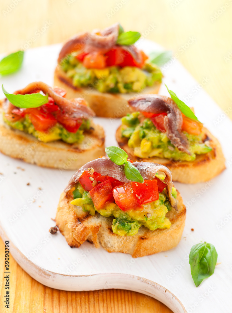 crostini with avocado,tomato and anchovy