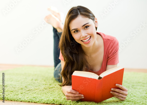 Young woman reading the book at home