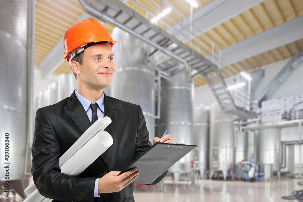Construction worker with helmet holding blueprints and writing o Construction worker with helmet holding blueprints and writing o