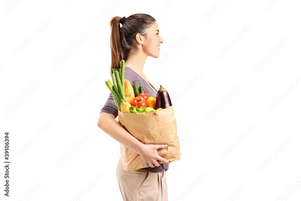 A female holding a paper bag with groceries A female holding a paper bag with groceries
