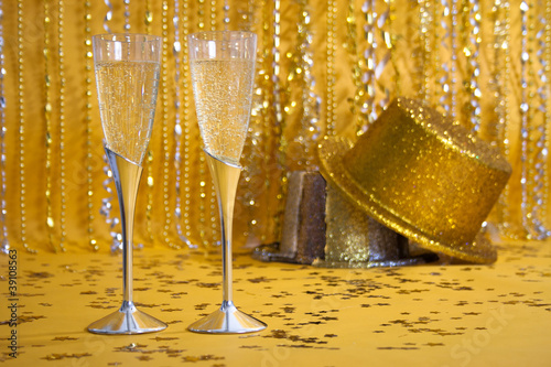 Silver Champagne Flutes and Gold and Slver Sequined Party Hats photo