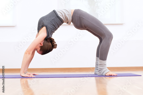 Woman doing stretching yoga exercise at sport gym photo