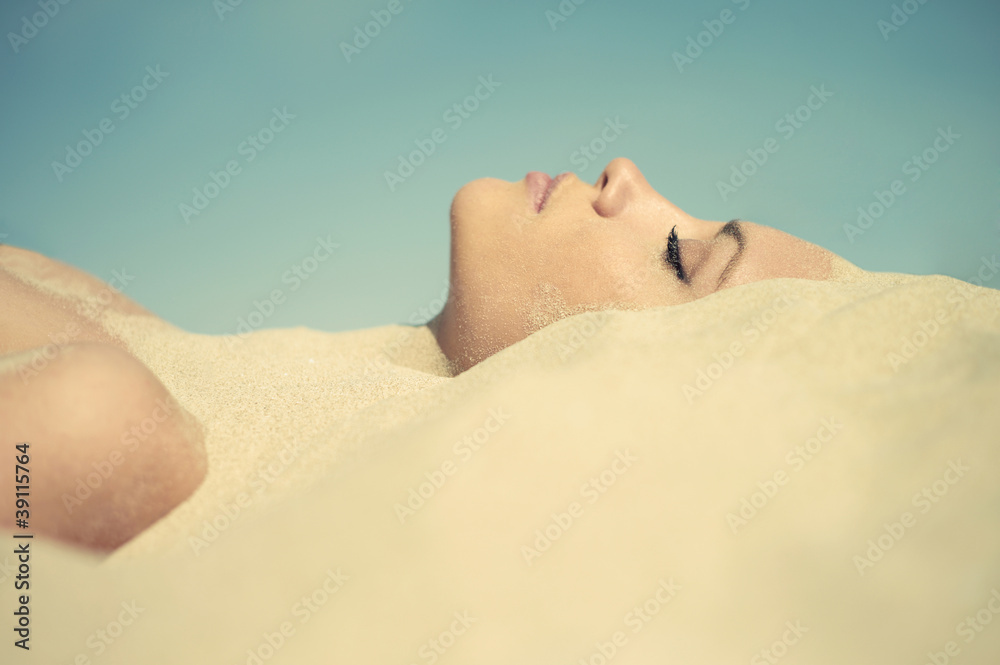 Fototapeta premium Beautiful lady buried in the sand