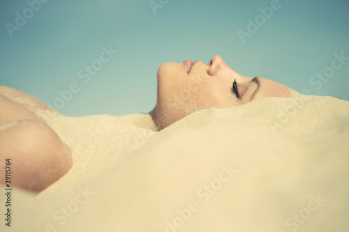 Beautiful lady buried in the sand photo