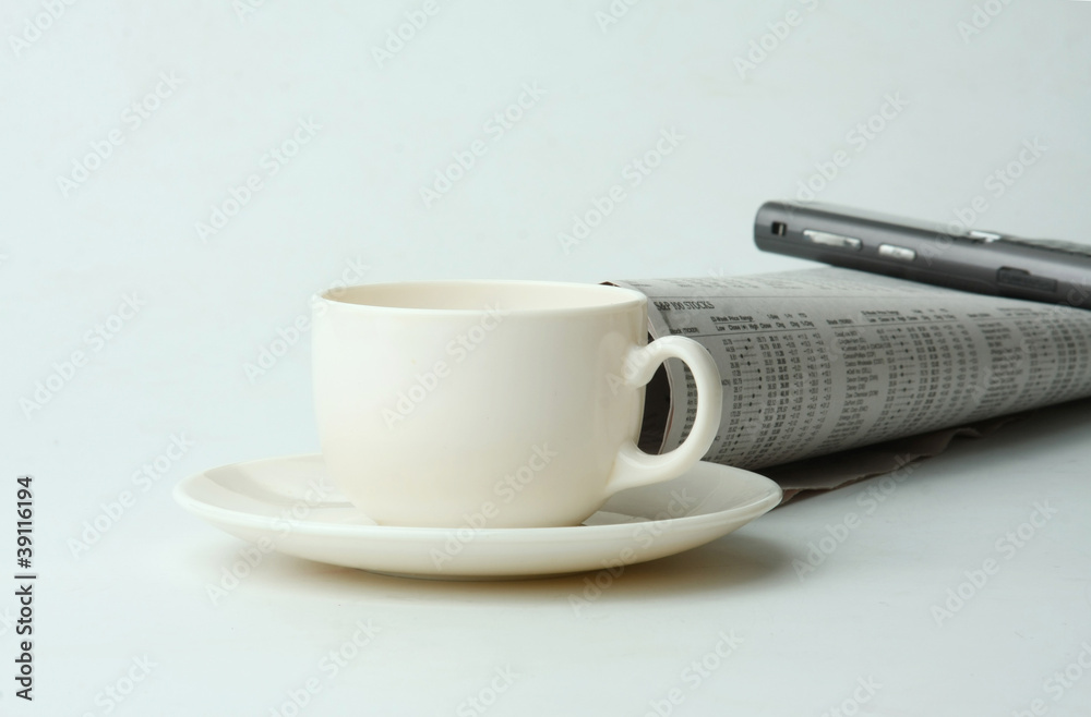A cup of coffee, a mobile phone and a newspaper A cup of coffee, a mobile phone and a newspaper