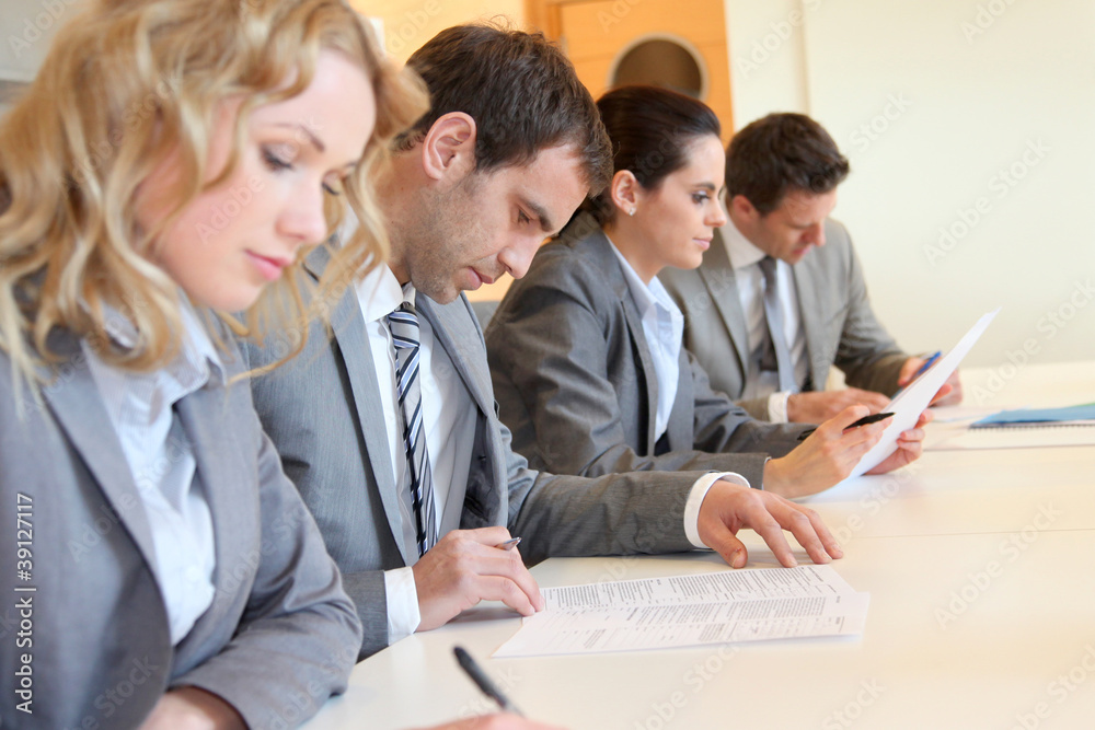 Young business people signing application form Young business people signing application form