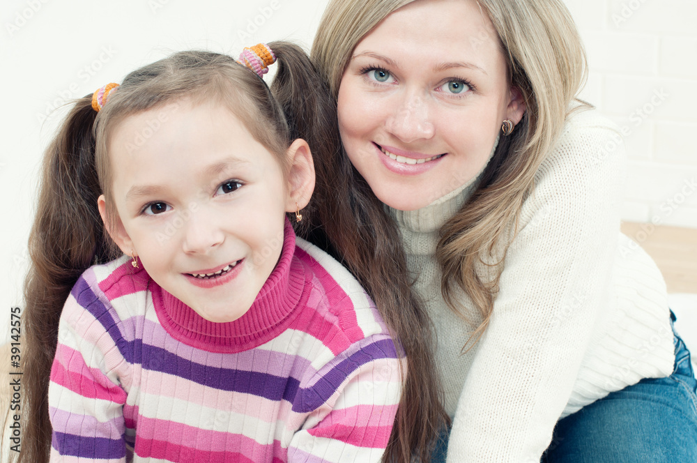 Pretty young woman and her little girl looking at camera Pretty young woman and her little girl looking at camera