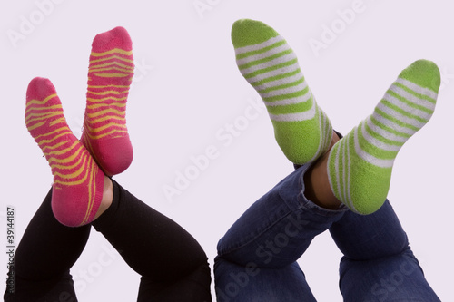 Two sets of girls feet wearing striped socks photo