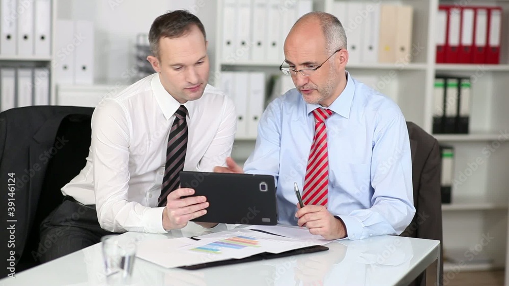 zwei geschäftsleute arbeiten mit tablet-pc im büro