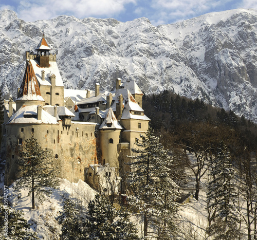 Dracula's Bran Castle in winter with snow and mountains. (2 superimposed images)