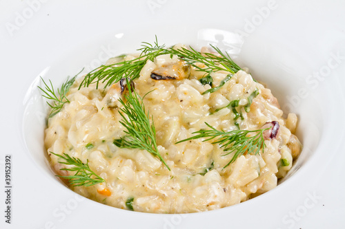 photo of delicious risotto with seafood and dill on it