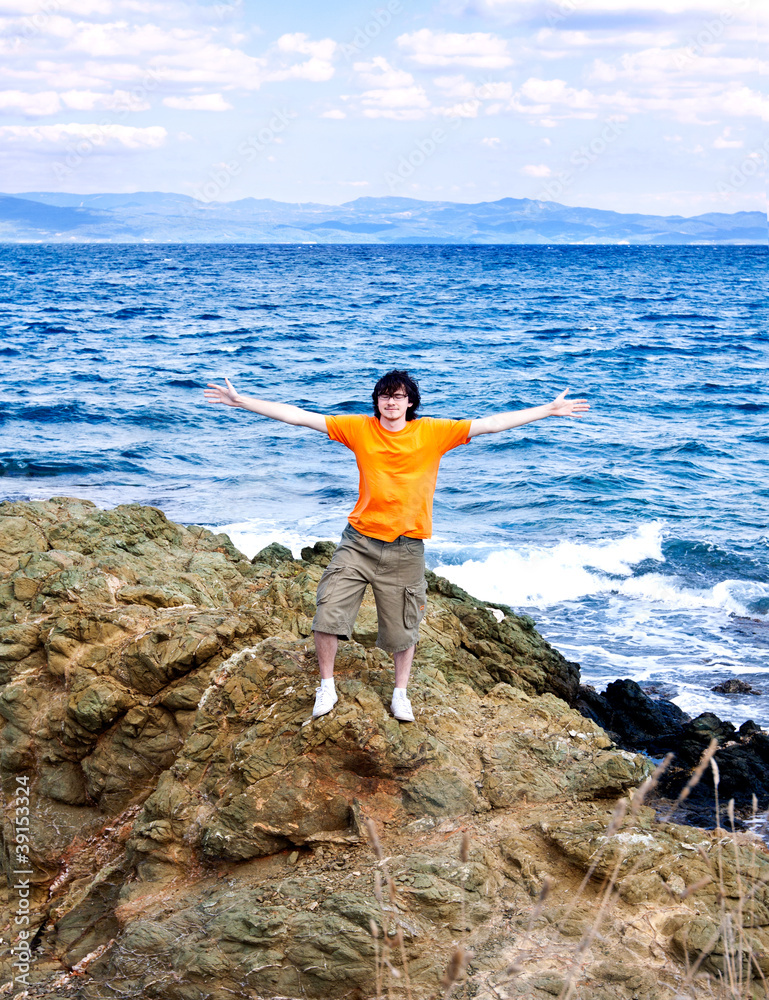 Obraz premium The young man at the sea on a stone