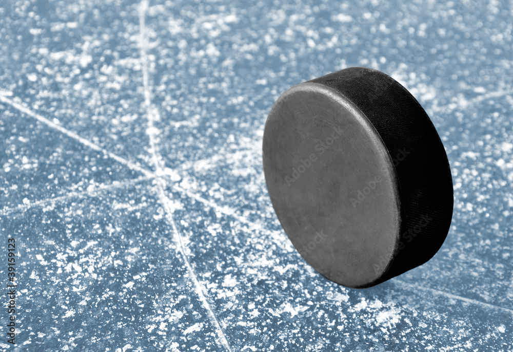black hockey puck on ice rink Stock Photo Adobe Stock