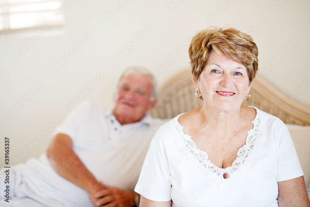 senior couple sitting on bed senior couple sitting on bed